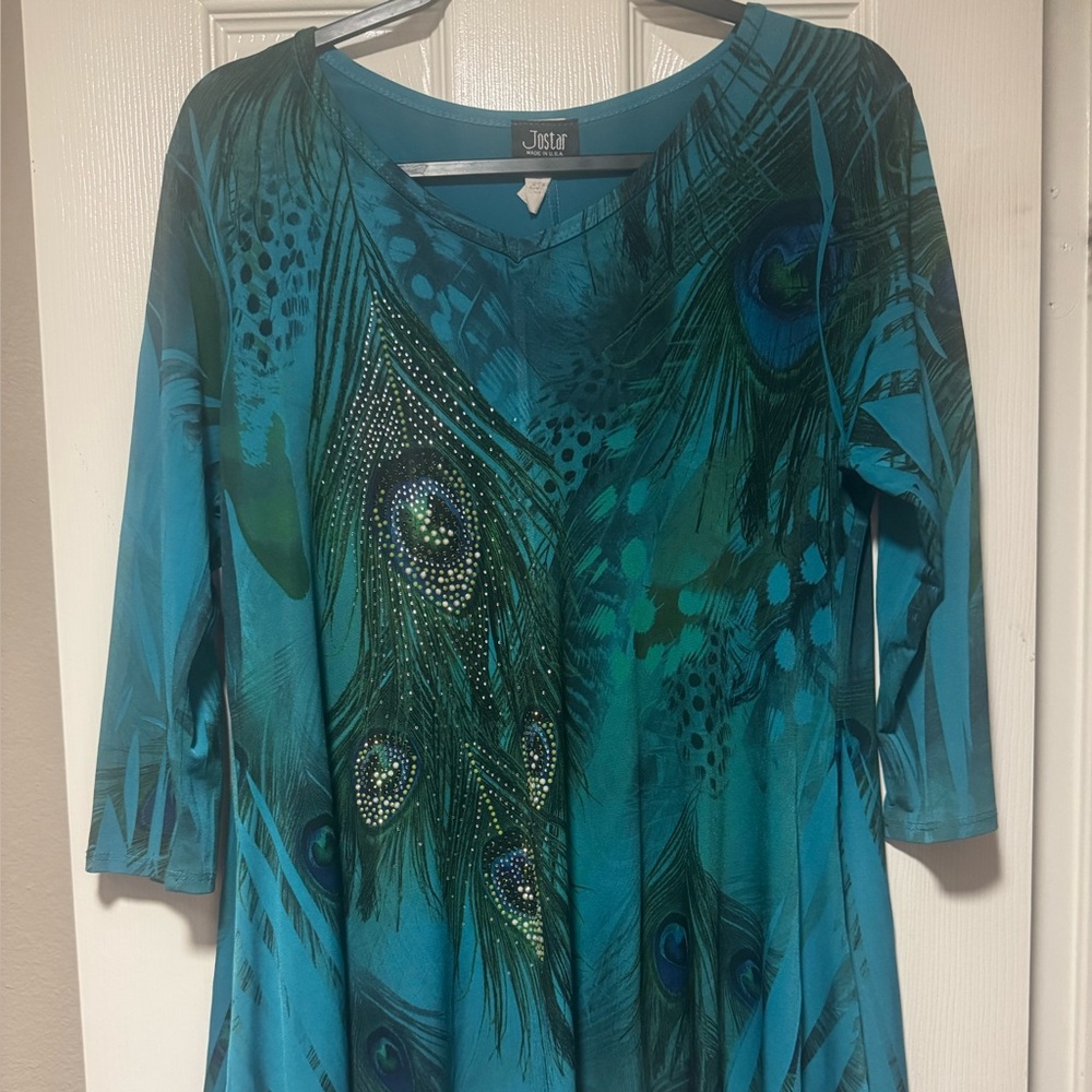 Jostar teal blouse. Embellished peacock feathers. Shark bite hem.